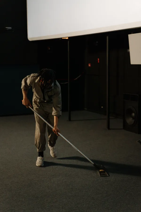 Uniformed technician treating a carpet stain during a commercial cleaning visit