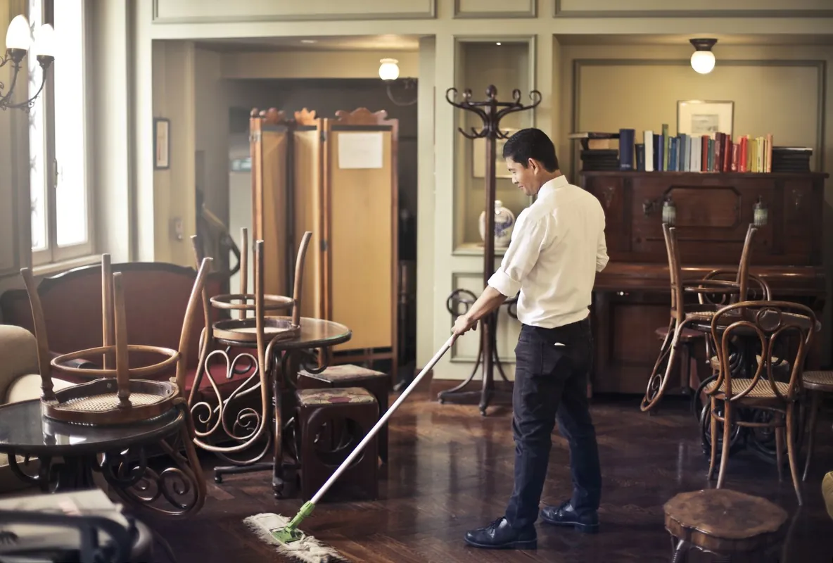 Cleaner mopping a Toronto restaurant dining room floor after closing